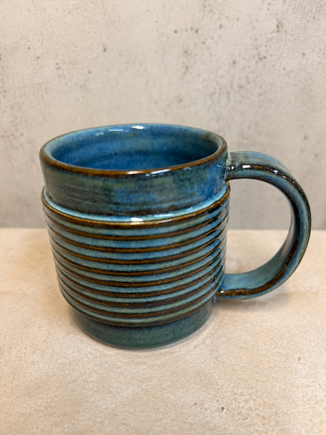Ribbed mug glazed in ocean blue with amber edges